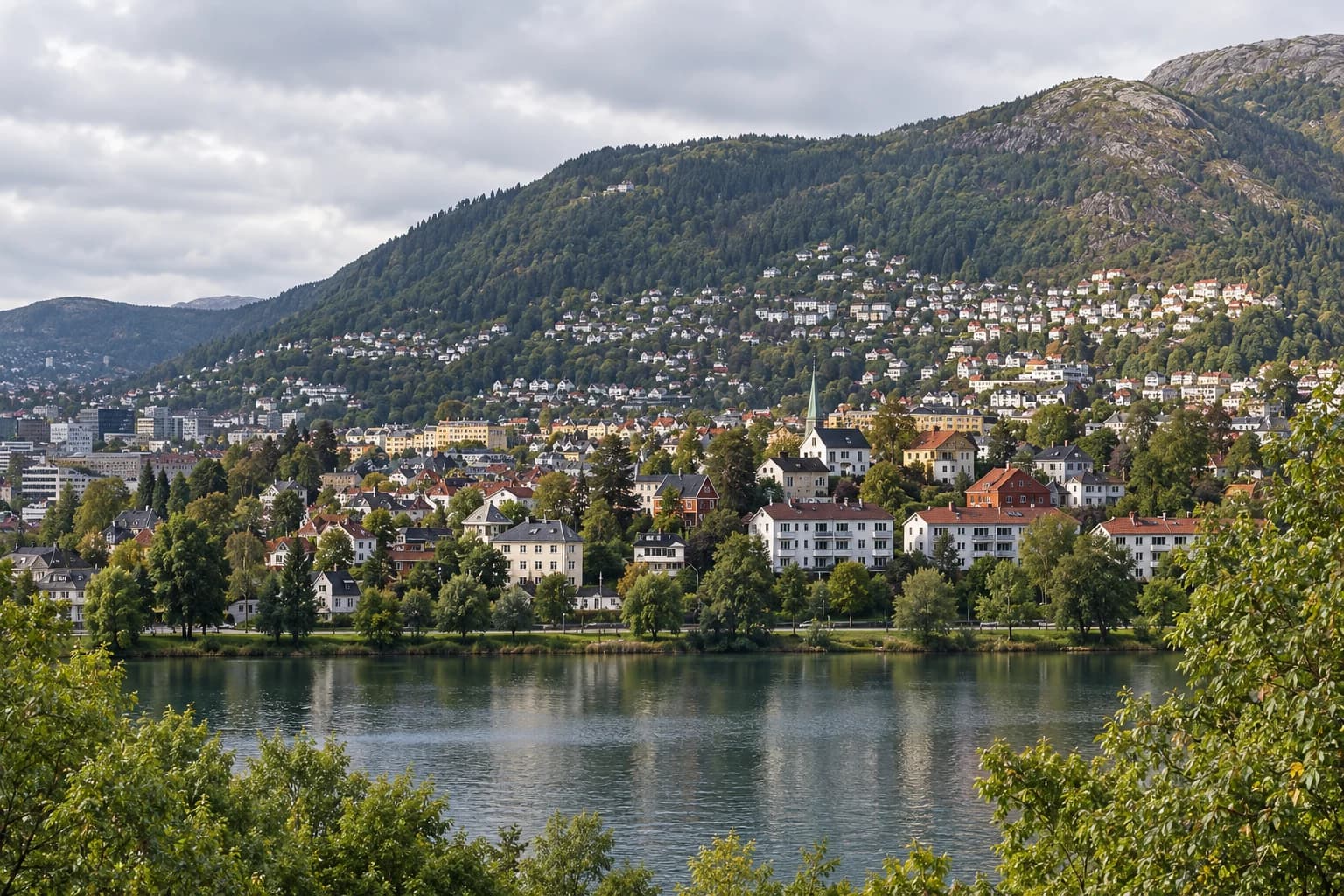 AI-illustrasjon inspirert av boligbebyggelse ved Tveitevannet med byfjellene bak.